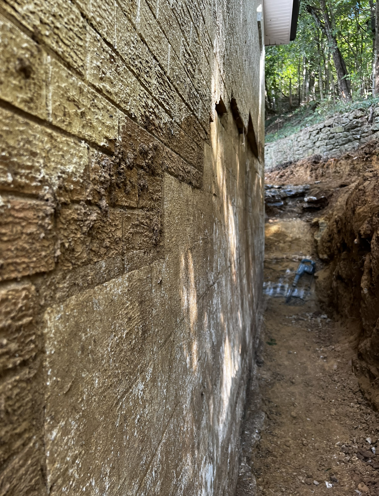 Hydrostatic wall failure — excavated, straightened, waterproofed — before