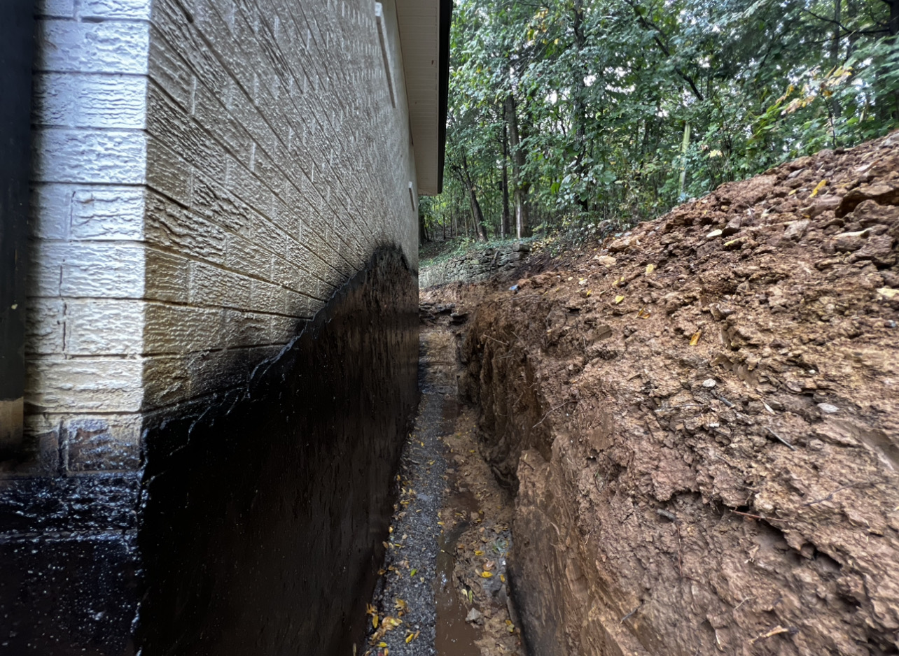 Hydrostatic wall failure — excavated, straightened, waterproofed — after